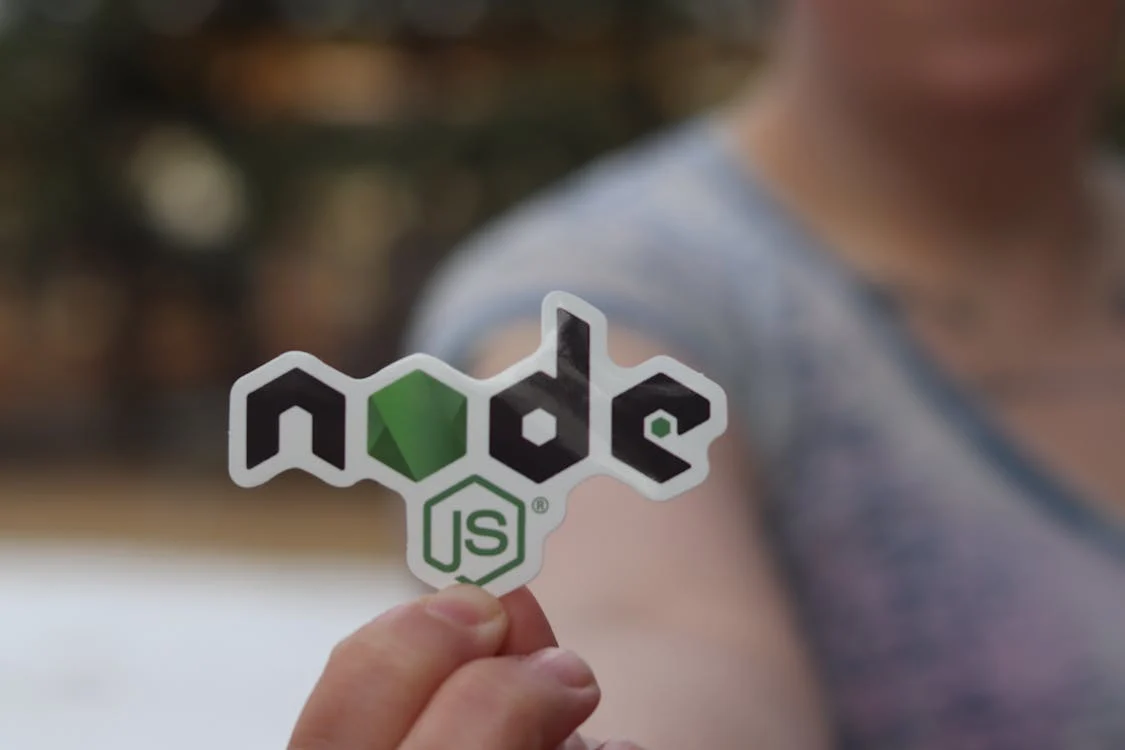 Photo d'une personne tenant en main le logo NodeJS